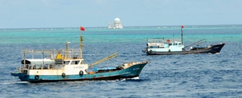 Fishing vessels sail past Zhubi Reef of south China Sea on July 18, 2012. A fleet of fishing vessels from China's southernmost province of Hainan departed from Yongshu Reef on Tuesday night. The fleet arrived at Zhubi Reef at about 10 a.m. Wednesday. The fleet of 30 boats, the largest ever launched from the island province, planned to fish and detect fishery resources near Zhubi Reef. (Xinhua/Wang Cunfu)